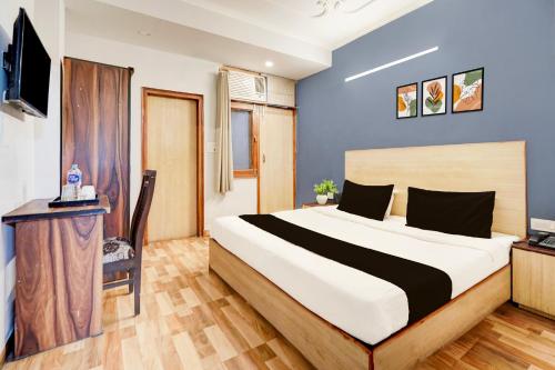 a bedroom with a large bed and a television at Super Collection O Sector 20 Noida in Noida