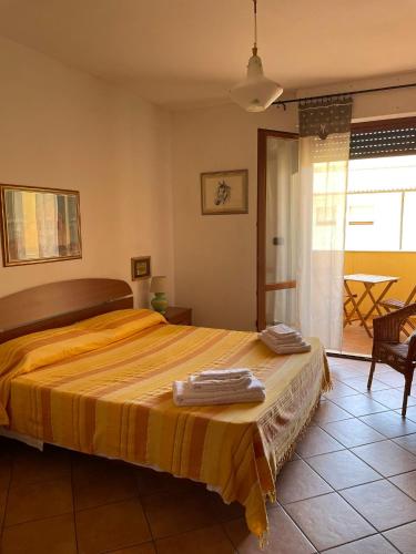 a bedroom with a large bed with a yellow blanket at Casa Roberta in Alghero