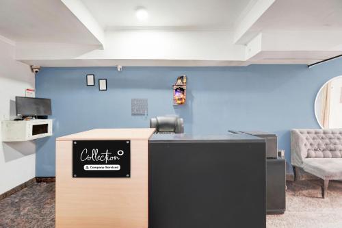 a reception desk in a room with a blue wall at Super Collection O Sector 20 Noida in Noida