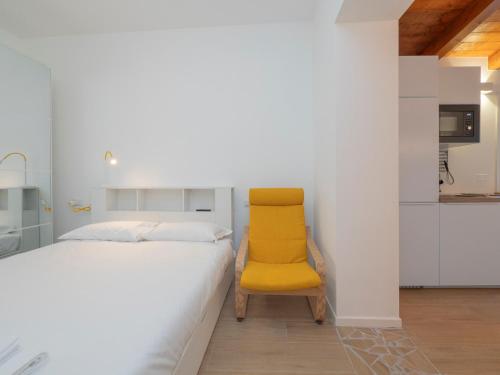 a bedroom with a yellow chair next to a bed at Luxury apartment - Flumendosa 5 in Milan