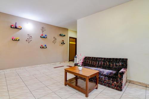 a living room with a couch and a table at Super Hotel O Akkayaplem Near Railway Station in Visakhapatnam