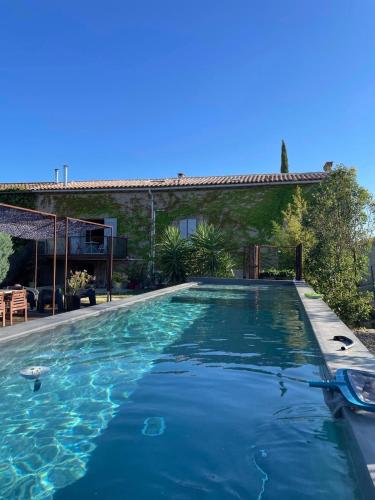 une piscine devant une maison dans l'établissement Les Grands Cyprès - chambres d'hôtes, à Conques-sur-Orbiel