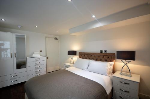 Bloomsbury Residences في لندن: غرفة نوم بسرير كبير وتلفزيون