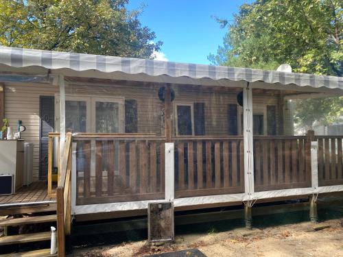 une terrasse couverte avec un toit sur une maison dans l'établissement MH 007 ELITE 3 chambres dont suite parentale et 2 salles de bain sur magnifique parcelle dans camping 4 étoiles, à Saint-Julien-en-Born