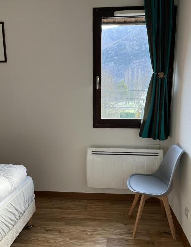- une chambre avec une chaise bleue et une fenêtre dans l'établissement Bagnères-de-Luchon T3, à Luchon