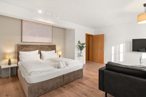 a bedroom with a large bed and a couch at YUVA HOMES in Untermeitingen in Untermeitingen