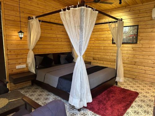 a bedroom with a bed with curtains in a cabin at Maya Nature Retreat by Ella's Escape in Mandrem