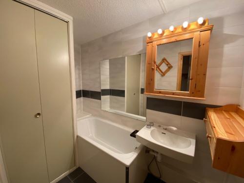 une salle de bain avec un lavabo, une baignoire et un miroir dans l'établissement Studio avec coin montagne pour 4 pers, skis aux pieds - FR-1-445-72, à Montgenèvre