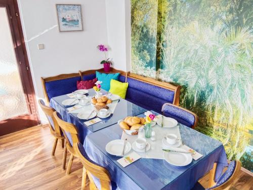 a dining room with a blue table and chairs at Frühstückspension See-Panorama in Podersdorf am See