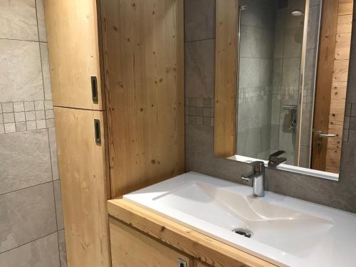 une salle de bain avec un lavabo et un miroir dans l'établissement Appartement rénové proche des pistes avec parking et balcon - FR-1-445-150, à Montgenèvre