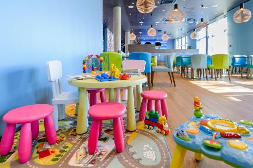 a room with a table and stools and tables and chairs at Ibis Styles Konstanz in Konstanz