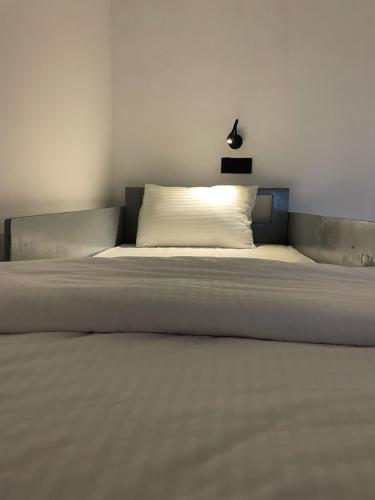 a large bed in a bedroom with a white bedsheet at Journey Junction Hostel in Nuwara Eliya