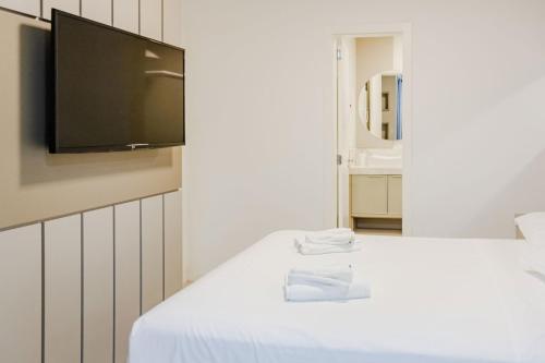 a room with a bed with a flat screen tv on the wall at Alto Padrão em Itapema, 8min a pé até o Mar FN8750 in Itapema