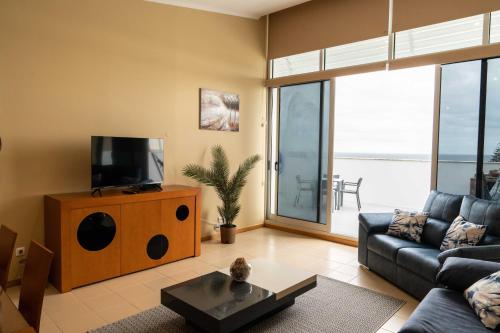 a living room with a couch and a television at Serra & Mar in Vila Franca do Campo