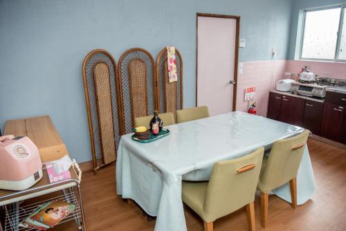 a dining room with a table and chairs and a kitchen at Benton Guesthouse, Private Nostalgic Showa-era House, former "Akiya" in Imabari