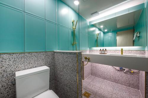 a bathroom with a toilet and a large mirror at Hotel eila in Pohang