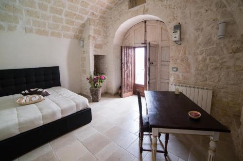 a bedroom with a bed and a table in a room at Borgovecchio Suite in Ostuni