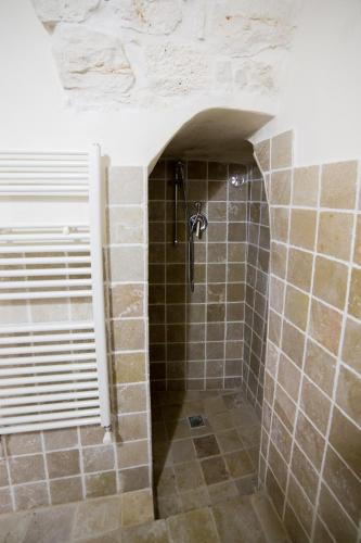 a shower in a bathroom with a tile floor at Borgovecchio Suite in Ostuni