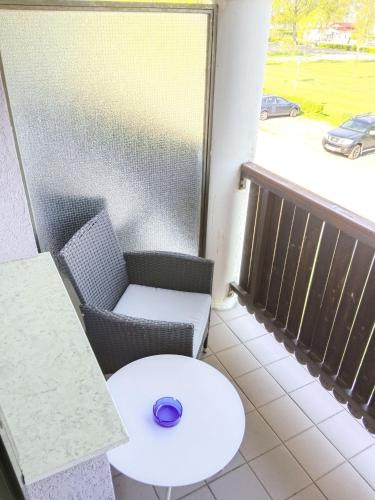 a table and chair on a balcony with a window at Frühstückspension See-Panorama in Podersdorf am See