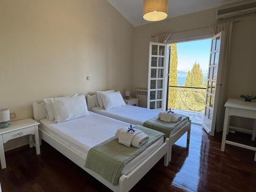 a bedroom with two beds and a large window at Athinas House in Corfu Town