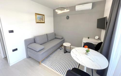 ein kleines Wohnzimmer mit einer Couch und einem Tisch in der Unterkunft Luxury Studio Rim Tim in Malinska