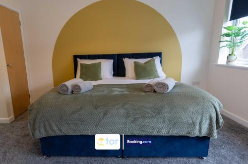 a bedroom with a large bed with towels on it at 2 Bedroom Apartment By The One Retreats Short Lets & Serviced Accommodation Horley Close To Gatwick Airport in Horley