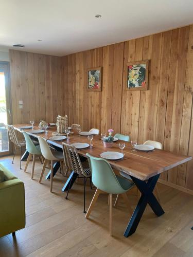une salle à manger avec une longue table en bois et des chaises dans l'établissement Villa de standing avec Piscine et Jacuzzi, à La Bruguière