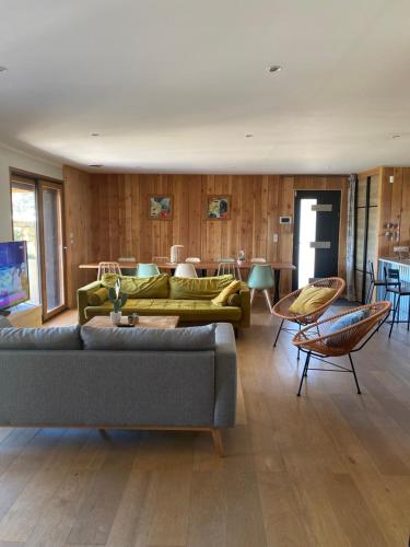 - un salon avec deux canapés, une table et des chaises dans l'établissement Villa de standing avec Piscine et Jacuzzi, à La Bruguière