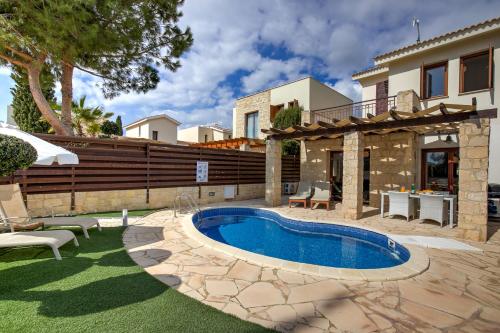 a backyard with a swimming pool and a house at Villa HG37 Kopiaste - Newly Refurbished Villa with Private Pool & Private Garden, Aphrodite Hills in Kouklia