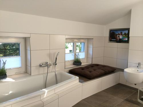 a bathroom with a tub and a sink and a bath tub at Landhaus Boddenhus in Polchow