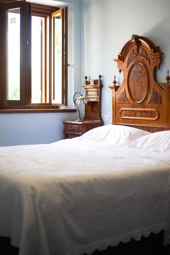 a bed with a wooden head board in a bedroom at Casa Ciclope in Arpino