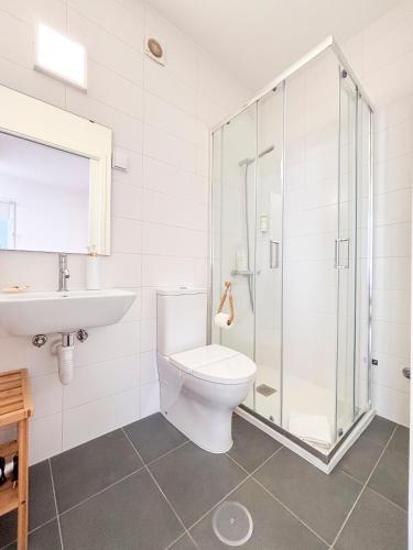 a bathroom with a shower and a toilet and a sink at Pedra do Mar in São Roque