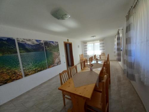 a dining room with a table and chairs and paintings at Willa nad Białką in Groń