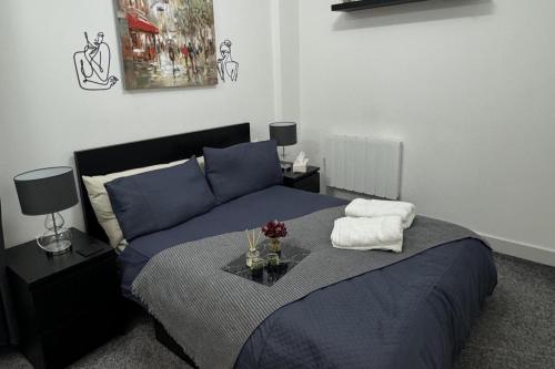 a bedroom with a blue bed with a table on it at 1 bed-Sleeps 4-Town Centre-10 min to Ascot- Pets in Bracknell