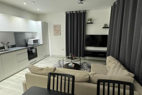 a living room with a couch and a kitchen at 1 bed-Sleeps 4-Town Centre-10 min to Ascot- Pets in Bracknell