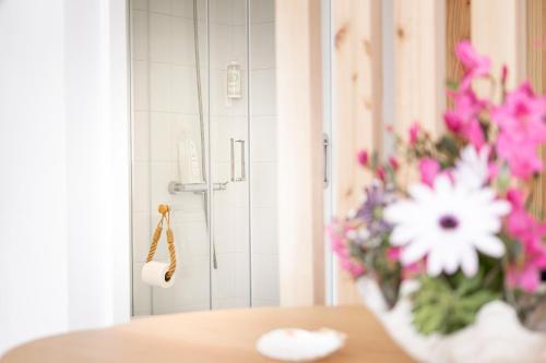 a vase of flowers sitting on a table in a bathroom at Pedra do Mar in São Roque