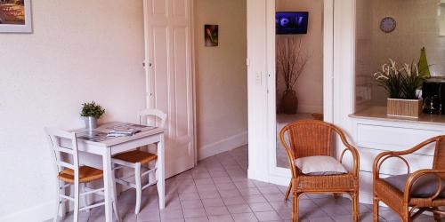 Cette chambre comprend une table, des chaises, une table et des chaises. dans l'établissement Studio résidence Grand Hôtel, à Châtel-Guyon
