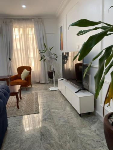 a living room with a flat screen tv on a cabinet at Blve Oak Apartments in Ikeja