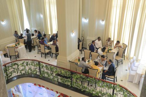 亚的斯亚贝巴Omna Addis Hotel的一群人坐在房间里的桌子旁