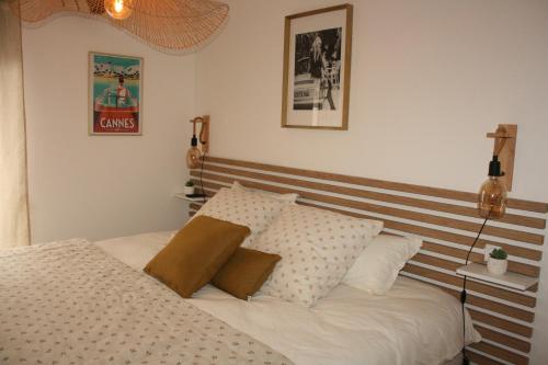 a bedroom with a white bed with a wooden headboard at La Maison Blanche 74 Annecy-le-Vieux in Annecy