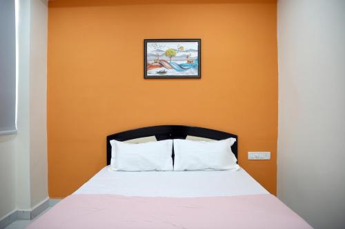 a bed in a room with an orange wall at PSV Grand in Hyderabad