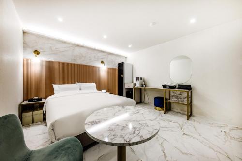 a hotel room with a bed and a table and a chair at Hotel eila in Pohang