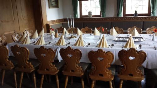 a table with a white table cloth and chairs at Erlebnislandgasthof Hotel Neiderhell in Kleinholzhausen