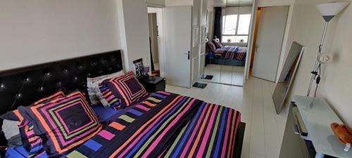 une chambre avec un lit avec des oreillers colorés dessus dans l'établissement Paris en hauteur, à Paris