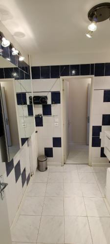 La salle de bains est pourvue de carrelage bleu et blanc et de toilettes. dans l'établissement Paris en hauteur, à Paris