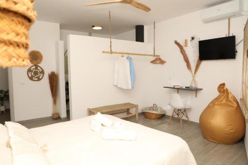 a white room with a bed and a table at Calas De Meca in Los Caños de Meca
