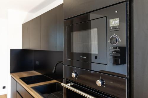 La cuisine est équipée d'un four micro-ondes noir. dans l'établissement La SerenBlue - chambre en colocation, à Collonges-sous-Salève