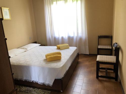 a bedroom with a bed with two yellow towels on it at IseoLakeRental - Villa Retrò in Riva di Solto