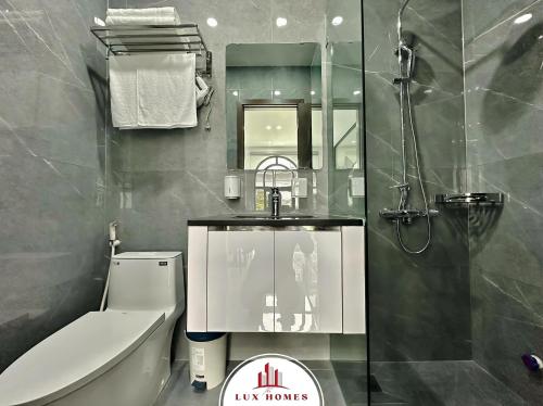 a bathroom with a toilet and a sink and a mirror at The LuxHomes Apartment ᵀᴹ I HOT Độc Đáo Nhất Vinhomes Marina in Hai Phong