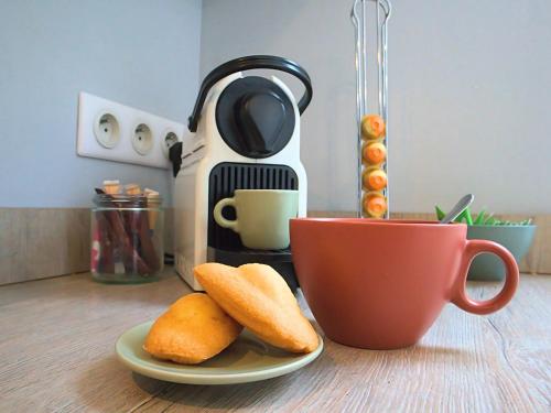 - une table avec une cafetière, 2 biscuits et une tasse dans l'établissement La Vue Cathédrale - Grande maison en hypercentre, Idéal Groupe, à Saint-Omer